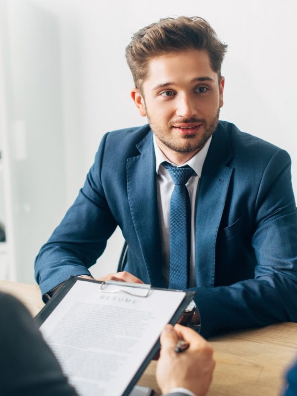 selective-focus-of-handsome-employee-looking-at-recruiter-during-job-interview.jpg